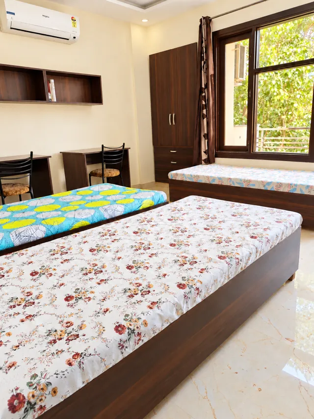 Bright shared bedroom with window and study desks